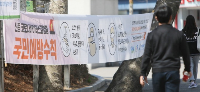한 학생이 31일 ‘코로나19 예방수칙’ 현수막이 걸려있는 인하대 후문가를 지나고 있다. 사진 인하대 제공