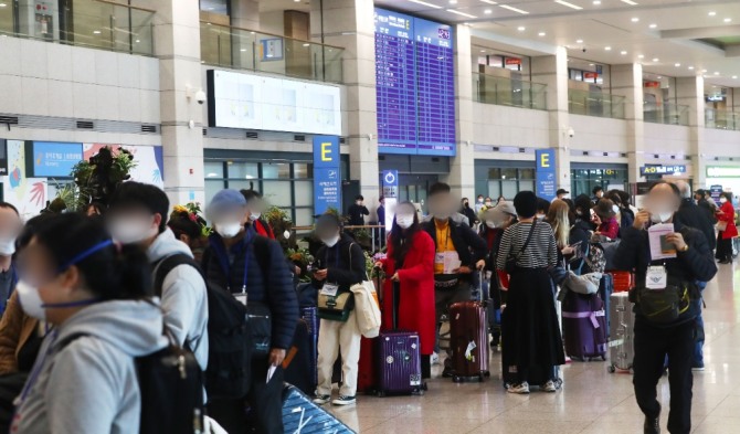 오늘부터 외국에서 국내로 들어오는 모든 입국자는 국적에 관계없이 2주간 의무적으로 자가격리를 해야 한다.인천공항 입국자 행렬.사진=뉴시스