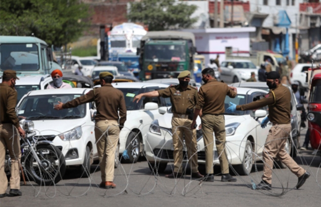 인도 북부 잠무카슈미르주에서 도시봉쇄 조치에 따라 경찰관들이 철조망으로 도로를 막고 주민들의 이동을 통제하고 있다.