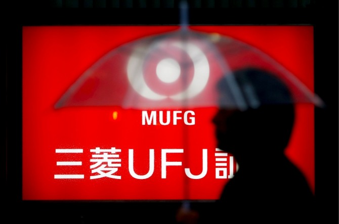 2009년 4월 21일 일본 도쿄 중심가에서 한 직장인이 일본 미쓰비시 UFJ(MUFJ) 금융그룹 로고 앞을 지나고 있다. 사진=연합뉴스