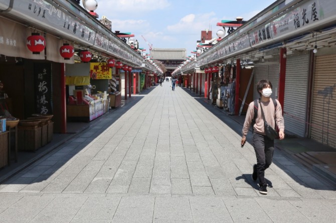 지난 8일 일본 도쿄 아사쿠사의 상점가 '나카미세' 거리가 텅 빈 가운데 한 시민이 마스크를 쓴 채 걸어가고 있다. 지난 7일 도쿄 등 7개 지역에 신종 코로나비아러스 감염증(코로나19) 확산을 막기 위해 긴급사태 선언이 발령됐다. 사진=뉴시스