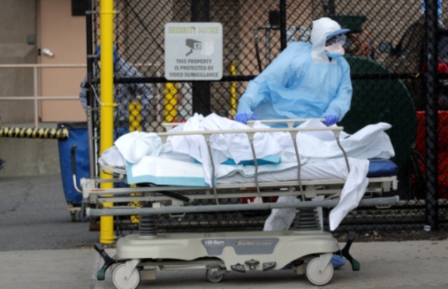 미국 뉴욕 브루클린에서 한 의료인이 신종 코로나바이러스 감염증(코로나19) 사망자의 시신을 병원 밖으로 옮기고 있다.