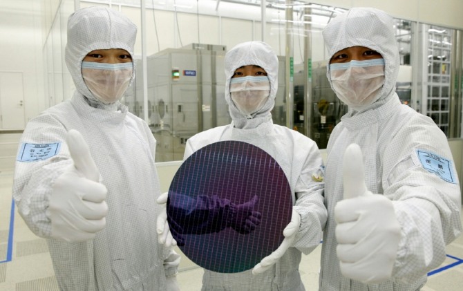 삼성전자 관계자들이 중국 시안 반도체 라인에서 생산된 낸드플래시 제품을 들어보이고 있다. 사진=뉴시스