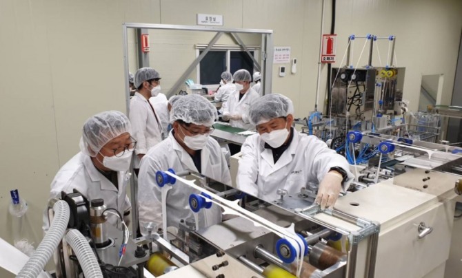 지난 2월, 화진산업 마스크 제조현장에서 삼성전자 멘토들이 마스크 제조 현장을 점검하고 있다. 사진=중소벤처기업부