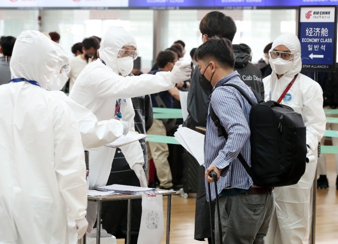 10일 인천공항에서 중국 톈진으로 출국하는 기업인들이 출국 수속을 위해 체온을 측정하고 있다.  뉴시스