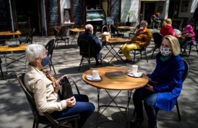 마스크를 착용한 채 카페의 야외 테이블에 앉아 있는 슬로바키아 시민들.
