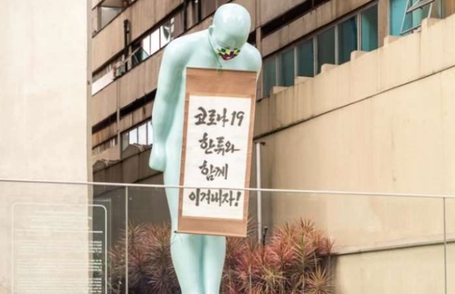 브라질 한국문화원이 브라질 국민의 신종 코로나바이러스 감염증(코로나19) 극복 노력을 응원하기 위해 지난 20일(현지시간) 건물 앞에 설치된 그리팅맨에 대형 마스크를 씌운 모습.