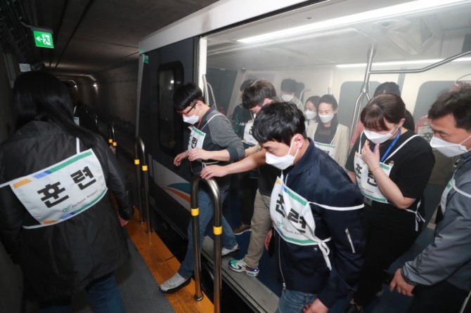 인천국제공항공사는 지난 21일 오후 인천공항 수하물처리시설 장애와 무인열차 화재를 가정한 ‘비상 합동훈련’에서 훈련에 참가한 가상승객들이 무인열차 화재 현장에서 대피하고 있다.(인전국제공항공사 제공)