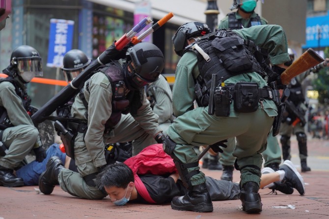 24일 홍콩 코즈웨이베이에서 중국의 국가보안법 제정에 반대하는 시위가 열린 가운데 경찰이 시위대를 진압하고 있다.  AP/뉴시스