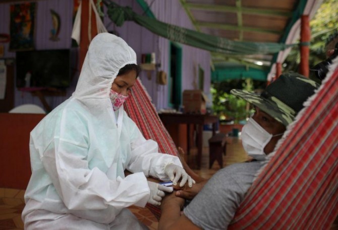 지난 21일(현지시간) 브라질 아마존의 원주민 거주지역인 트레스우니도스 마을에서 코로나에 감염된 남성 환자를 간호사가 돌보고 있다. 사진=로이터