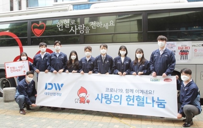지난 22일 서울 중구 서울사무소 인근에서 열린 대우산업개발 임직원 '사랑의 헌혈나눔' 행사에 한재준 대표이사(오른쪽 5번째)와 직원들이 마스크를 끼고 행사사진을 찍고 있다. 사진=대우산업개발