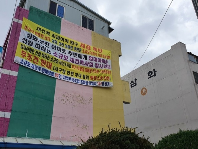 광주광역시 서구 죽봉대로 한 아파트 벽에 소규모재건축사업을 결사 반대한다는 현수막이 내걸려 있다.