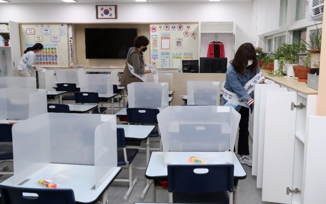 등교 개학을 하루 앞둔 지난 26일 오후 서울 양천구 경인초등학교 1학년 교실에서 학부모회 봉사단이 방역작업을 하고 있다. 사진=뉴시스