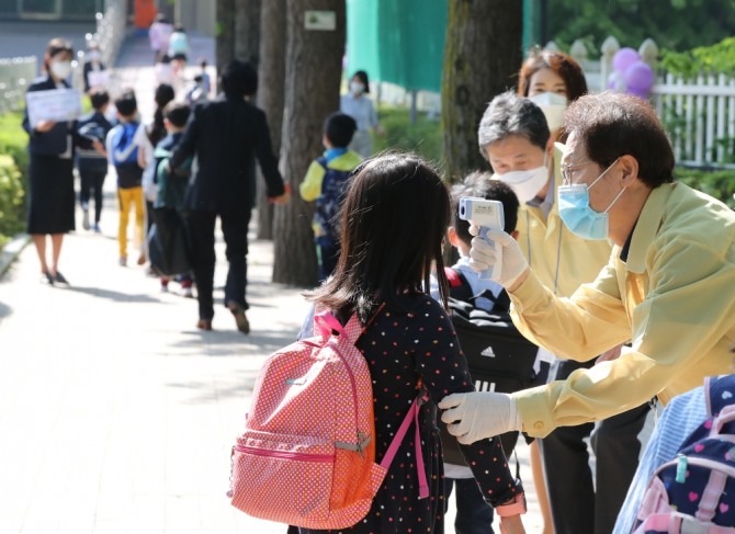 조희연 서울시교육감이 27일 오전 서울 송파구 세륜초등학교에서  등교하는 초등학생들에게 발열체크를 하고 있다. 사진=뉴시스