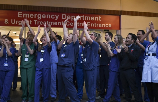 영국 국민보건서비스(NHS) 소속 코로나19 의료진이 런던의 병원 밖에서 “보살피는 이들을 위해 박수를‘(Clap for Carers) 캠페인에 동참하고 있다.