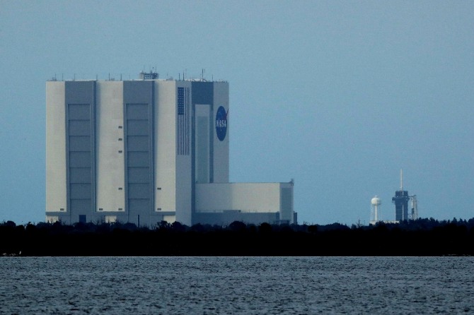 미국의 민간 우주개발사 스페이스X의 유인우주선 '크루 드래건'이 탑재된 팰컨 9 로켓이 26일(현지시간) 플로리다주 케이프 커내버럴의 케네디 우주센터 P39-A 발사대(오른쪽)에 세워져 있다.  AP/뉴시스