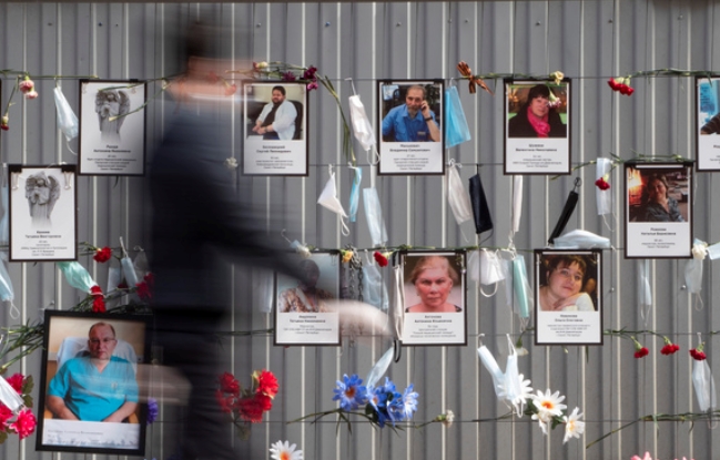 코로나19 사망자가 급증하고 있는 러시아 모스크바 거리의 한 벽에 희생자들의 사진과 추모의 글이 내걸려 있다.