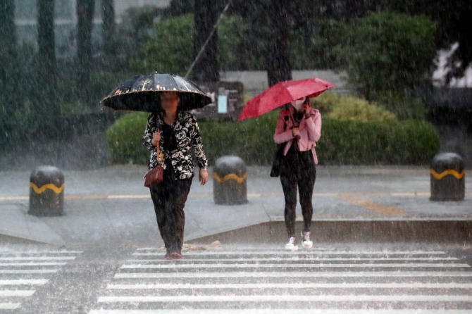 지난 18일 오후비가 내리는  서울 중구 일대에서 한 시민들이 우산을 쓰고 있다. 사진=뉴시스