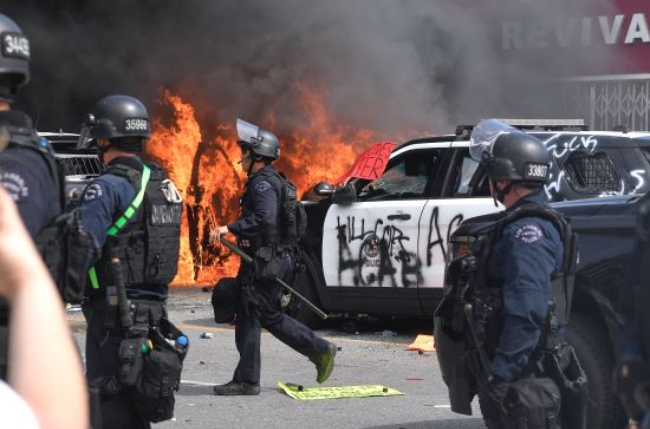 미국 캘리포니아주 로스앤젤레스에서 지난달 30일(현지시간) 경찰에 의한 흑인사망에 분노한 시위대가 경찰차들을 불태우거나 파손하고 있다. 
