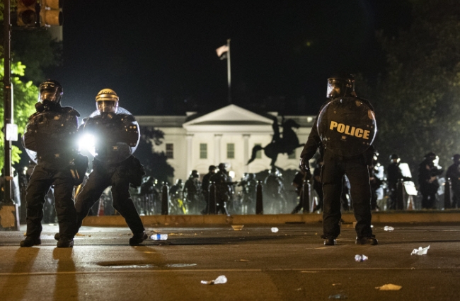 미국 워싱턴 백악관 근처에서 지난달 31일(현지시간) 흑인 남성 조지 플로이드의 사망에 항의하는 시위대가 백악관에 접근하는 것을 막기 위해 경찰이 진압 대형을 갖추고 있다.