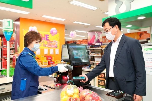 홍경식 금융정보화추진협의회 사무국장 겸 한국은행 금융결제국장(오른쪽)이 마트에서 모바일 현금카드 서비스를 이용한 결제를 시연하고 있다. 사진=한국은행