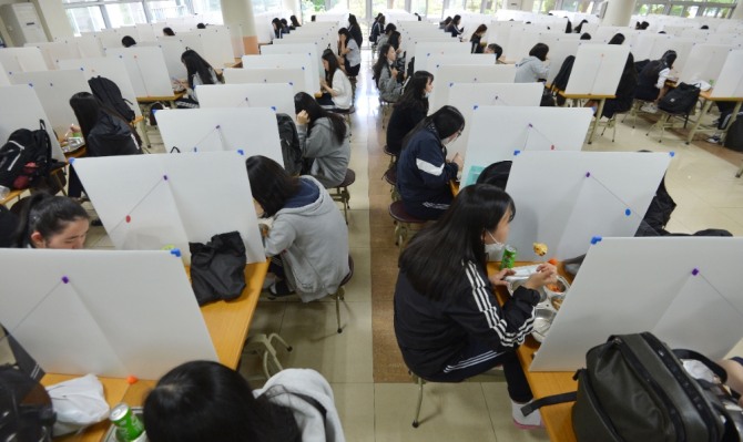 대구 경북여자고등학교에서 학생들이 신종 코로나바이러스 감염증(코로나19) 예방을 위해 칸막이가 설치된 급식실에서 지그재그로 간격을 벌려 앉아 점심을 먹고 있다.