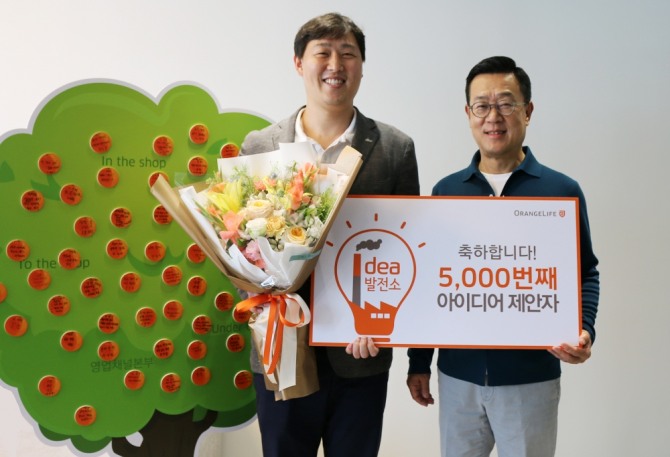 서울 중구 순화동 오렌지센터에서 5000번째 아이디어를 제안한 오렌지라이프 직원과 정문국 사장이 기념촬영을 하고 있다. 사진=오렌지라이프
