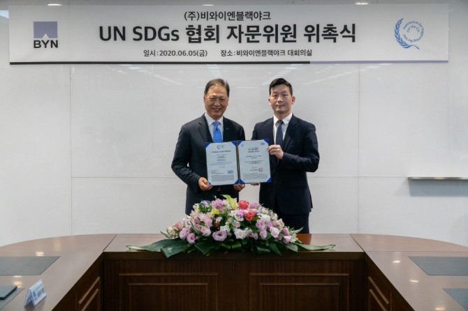 강태선 비와이엔블랙야크 회장(사진 왼쪽)과 김정훈 UN SDGs 협회 대표가 기념촬영을 하고 있다. 사진=비와이엔블랙야크