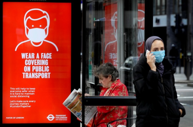 5일(현지시간) 영국 런던의 한 버스 정류장에 대중교통 이용 때 마스크 착용을 권고하는 광고가 설치돼 있다. AP/뉴시스
