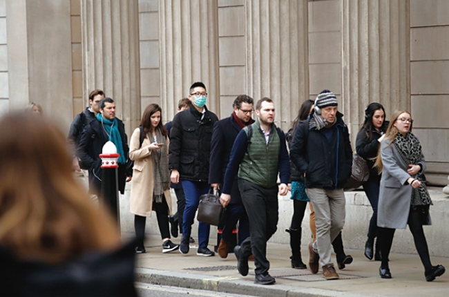 영국 런던의 잉글랜드 은행 앞을 지나는 시민들. 동양인으로 보이는 한 남자만 마스크를 착용하고 있는 모습에서 정부의 코로나19 대책이 얼마나 부실했는지를 알 수 있다.