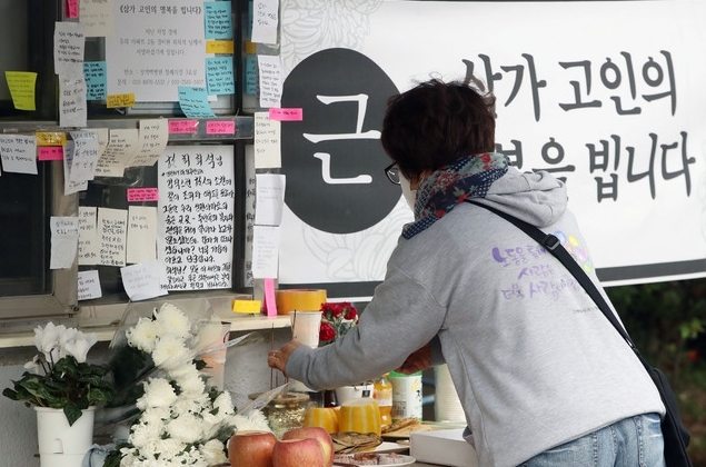 5월 12일 서울 강북구의 한 아파트 경비실 앞에 마련된 고 최모 경비원를 위한 추모 공간에서 한 시민이 분향을 하고 있다. 사진=뉴시스 