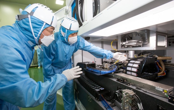 삼성전자 직원(왼쪽)과 이오테크닉스 직원(오른쪽)이 양사가 공동 개발한 반도체 레이저 설비를 함께 살펴보고 있다. 사진=삼성전자 제공