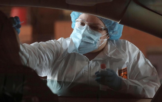 미국의 한 의료요원이 애리조나주 톨레슨에서 자동차 탑승객을 대상으로 코로나19 감염여부 테스트를 하고 있눈 모습. 사진=로이터