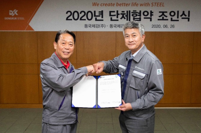 장세욱 동국제강 대표이사(오른쪽)와 박상규 노조위원장이 26일 합의서를 들고 주먹 인사를 나누고 있다. 사진=동국제강