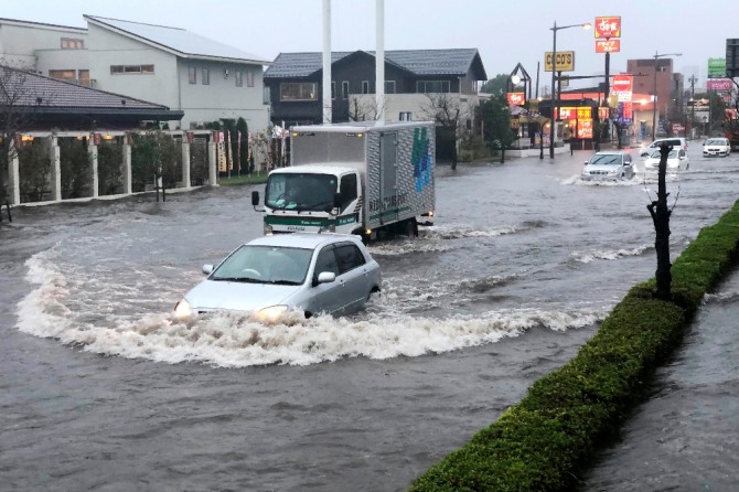 25일 도쿄 동쪽 나리타에 호우가 내려 거리가 물에 잠겨 있다. AP/뉴시스 