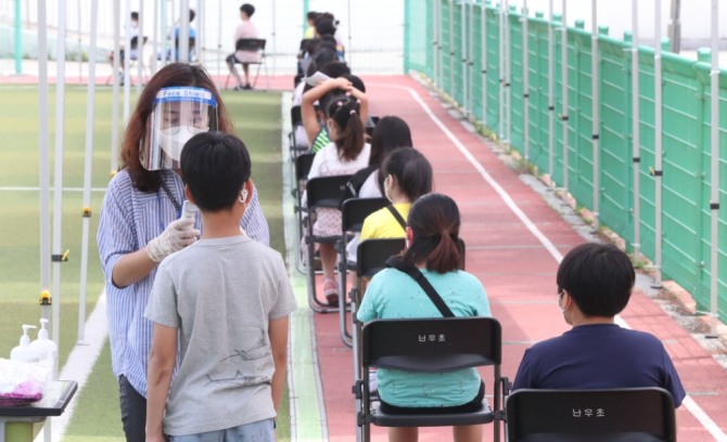 왕성교회 신종 코로나바이러스 감염증(코로나19) 집단감염 관련 확진자 중 한 명이 난우초등학교 시간강사로 밝혀진 가운데 28일 오전 서울 관악구 난우초등학교에 마련된 이동 선별진료소에서 학생들이 체온을 재고 있다. 사진=뉴시스