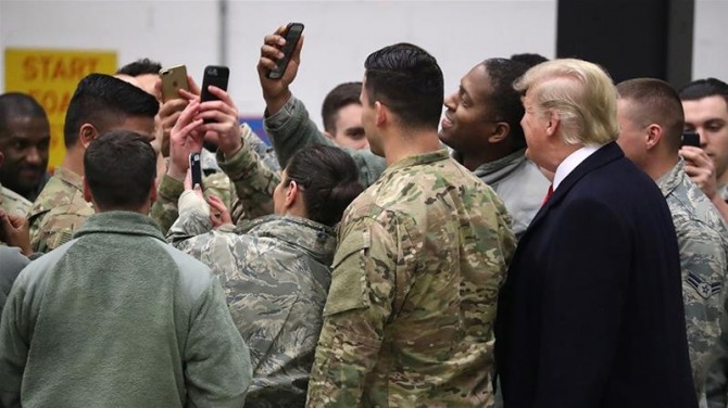 도널드 트럼프 미국 대통령이 지난 2018년 12월 독일 람슈타인에 있는 미군 공군기지를 방문한 자리에서 장병들과 함께 사진을 찍고 있다. 사진=로이터