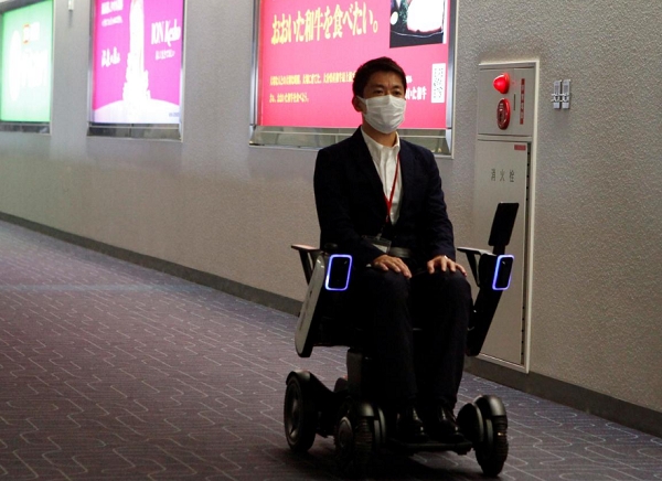 한 공항 이용객이 일본 하네다공항에 도입된 자율운전 힐체어를 타고 목적지로 이동하고 있는 모습. 사진=로이터 