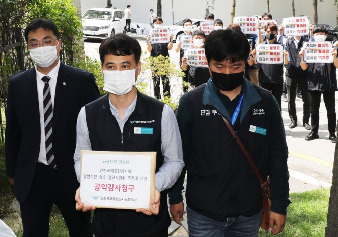 장기호 인천국제공항공사 노조위원장이 9일 인천국제공항공사의 비정규직 보안검색요원 정규직 전환 추진에 대한 공익감사 청구서를 들고 서울 종로구 감사원에 들어서고 있다.사진=뉴시스