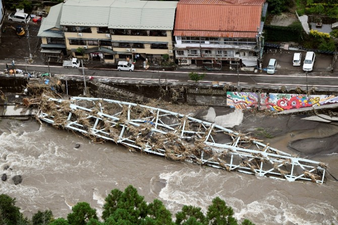 일본 오이타현 히타에 8일 기록적인 폭우로 불어난 강물에 끊긴 다리 구조물이 쓰러져 있다. AP/뉴시스