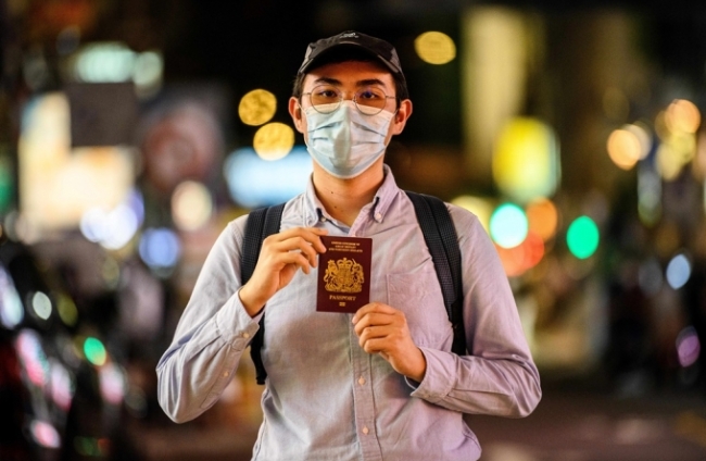 홍콩의 한 거리에서 영국의 BNO 여권을 든 남성이 포즈를 취하고 있다.