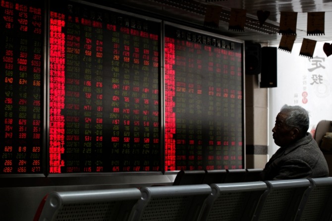 중국 베이징의 한 증권회사에서 한 투자자가 주식 시세를 보여주는 전광판을 지켜보고 있다. 사진=뉴시스