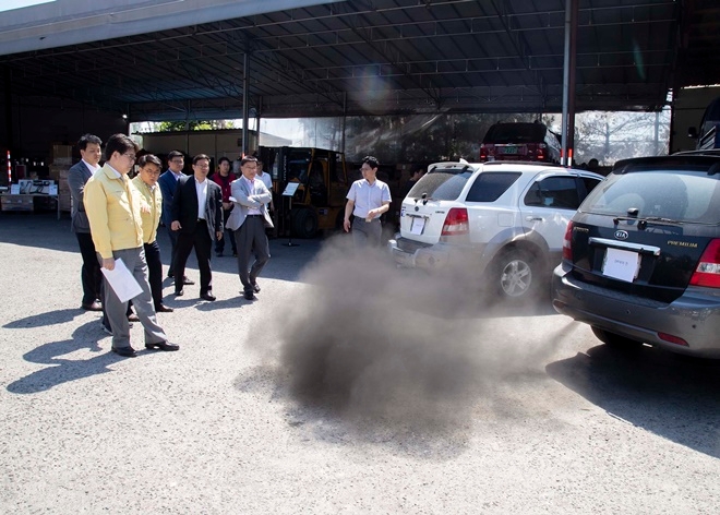 조명래 환경부 장관(앞줄 왼쪽)이 지난해 5월 31일 경기도 수원에 있는 자동차 공업사를 방문해 노후 경유차에 배출가스저감장치를 부착하는 모습을 지켜보고 있다.  사진=뉴시스