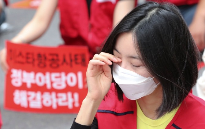 지난 20일 서울 마포구 애경본사 앞에서 이스타항공 조종사노조 주최로 진행된 '이스타 항공 인수 촉구 집회'에서 한 참석자가 눈물을 훔치고 있다.[사진=뉴시스]