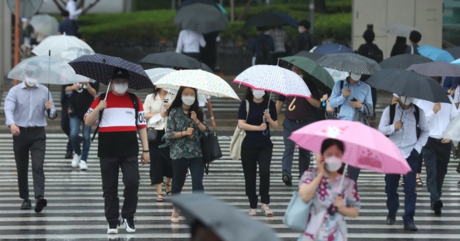 전국 대부분 지역이 흐리거나 비가 내리고 있는 지난 20일 오전 서울 여의도환승센터에서 시민들이 우산을 쓰고 출근하고 있다. 사진=뉴시스