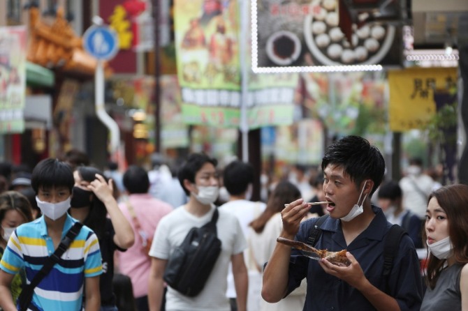 일본 도쿄 인근 요코하마의 차이나타운에서 코로나19 확산을 막기 위해 마스크를 착용한 사람들이 중국 음식을 먹고 있다. AP/뉴시스