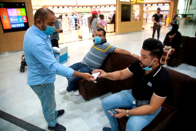 이라크 바그다드 국제공항에서 코로나19 예방을 위해 마스크를 배포하고 있다. AP/뉴시스
