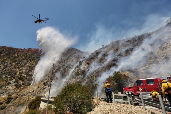 1일 미국 캘리포니아주 아주라의 국립수목원에서 발생한 산불로 소방대원들이 헬기와 함께 진화작업을 펴고 있다. 신화/뉴시스