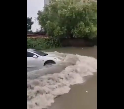 지난 5일 한 중국 시민이 트위터에 올린 동영상. 물로 가득찬 도로 위를 테슬라 전기차가 물을 가르며 주행하고 있다. 사진=트위터