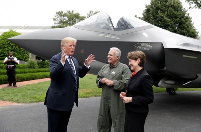 도널드 트럼프 미국 대통령(왼쪽)이 지난 2018년 7월 23일(현지시간) 미국산 제품 전시를 위해 백악관에서 개최한 '메이드 인 아메리카' 전시회에서 미국 항공방산업체 록히드마틴의 F35 전투기 앞에 서서 마릴린 휴스 회장(오른쪽), 조종사 앨런 노먼과 대화하고 있다. 사진=뉴시스